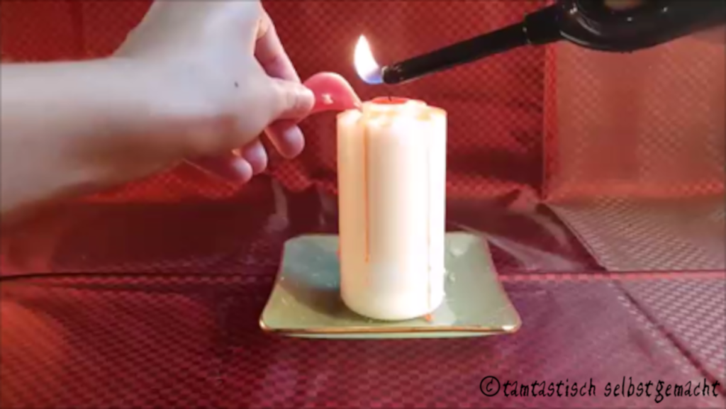 rote Wachsreste über einer Kerze schmelzen um eine blutende Kerze selber zu machen