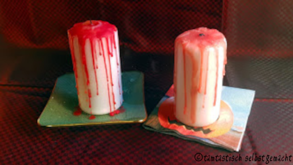 zwei angezündete blutende Kerzen